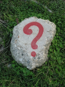 a red question mark painted on a piece of concrete