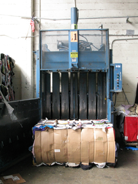 a baler with a bale of clothing to be sold for scrap
